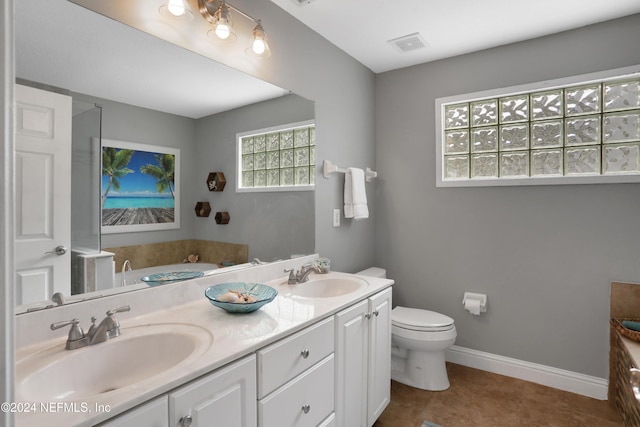 bathroom featuring tile patterned flooring, vanity, toilet, and a bath