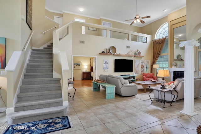 living room featuring a high ceiling, light tile patterned floors, ceiling fan, and crown molding