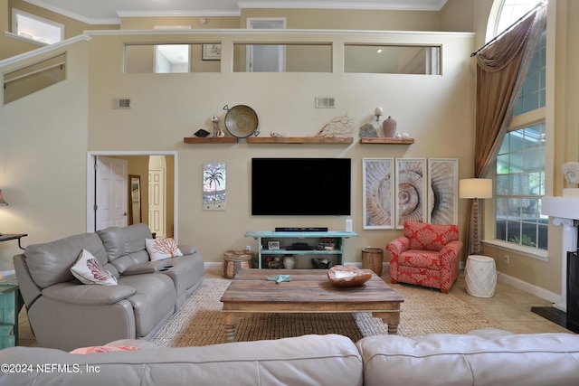 living room with light tile patterned flooring, ornamental molding, and a high ceiling