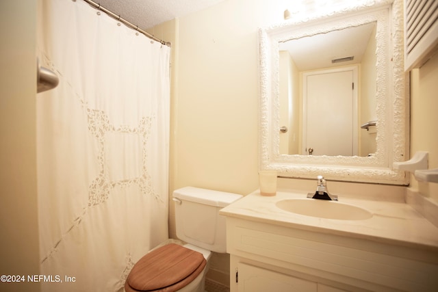 bathroom featuring vanity, a textured ceiling, and toilet