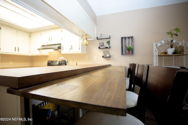 bar with white cabinets and exhaust hood