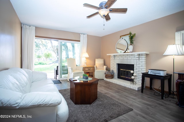 living room with dark hardwood / wood-style flooring, a brick fireplace, and ceiling fan