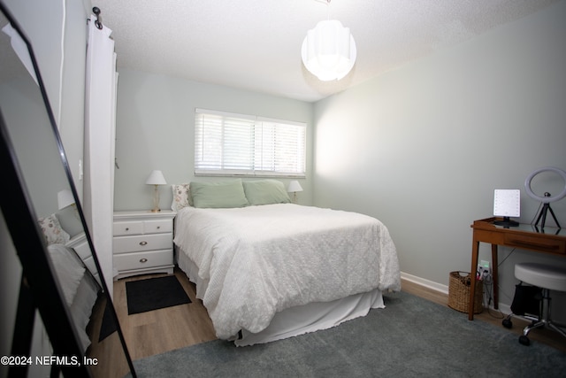 bedroom with dark hardwood / wood-style flooring and a textured ceiling