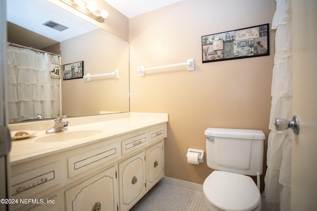 bathroom featuring tile patterned floors, vanity, and toilet