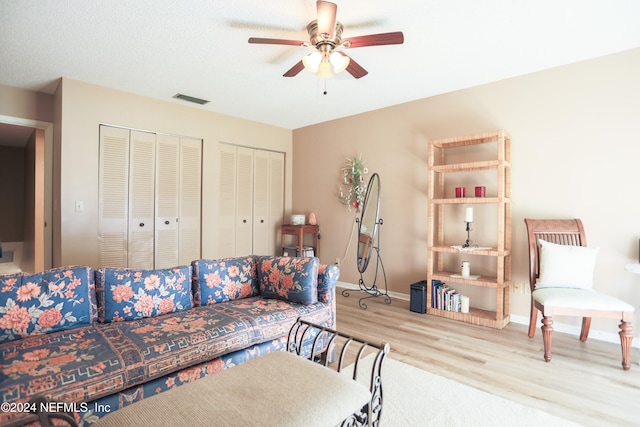 living room featuring light hardwood / wood-style flooring and ceiling fan