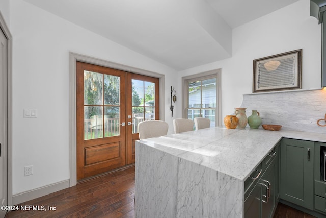 kitchen featuring french doors, dark wood-type flooring, kitchen peninsula, lofted ceiling, and green cabinetry