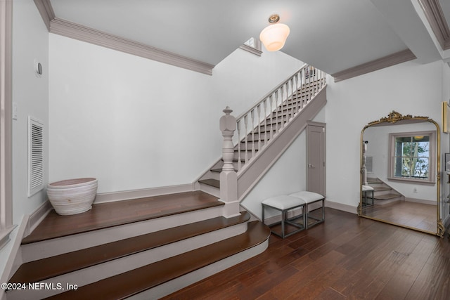 staircase with hardwood / wood-style floors and ornamental molding