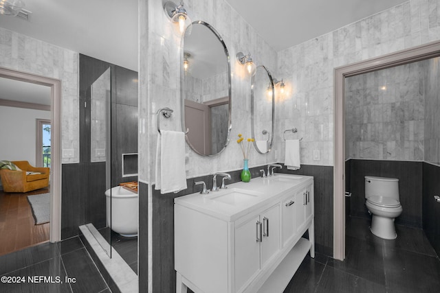 bathroom with vanity, crown molding, tile walls, tile patterned flooring, and toilet