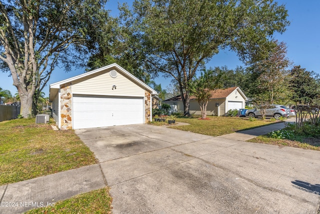 exterior space featuring central AC, an outbuilding, a front lawn, and a garage