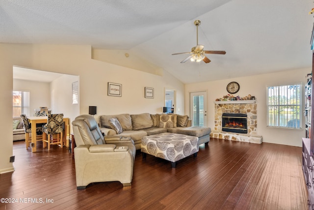 living room with dark hardwood / wood-style floors, ceiling fan, lofted ceiling, and a fireplace