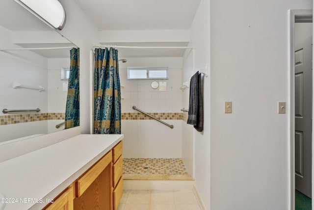 bathroom featuring tile patterned flooring, vanity, and walk in shower