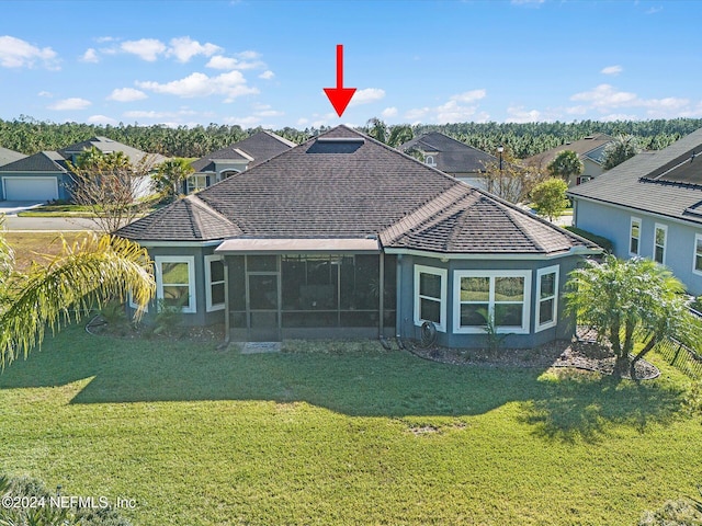 back of property featuring a sunroom and a yard