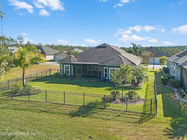 back of house with a lawn and a sunroom