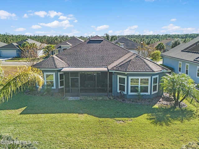 back of property with a lawn and a sunroom