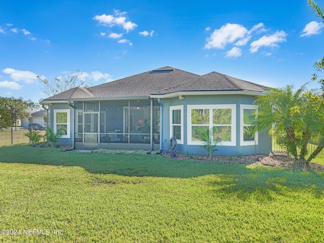 rear view of house with a lawn and a sunroom