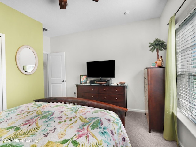 carpeted bedroom with ceiling fan and multiple windows