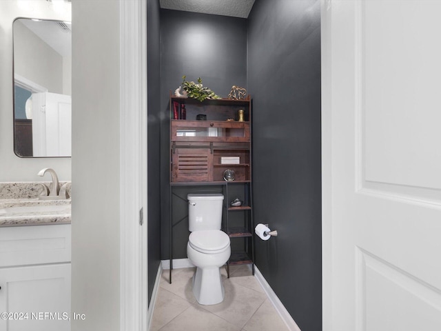 bathroom with tile patterned flooring, vanity, and toilet