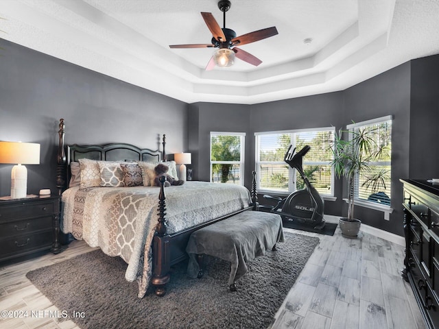 bedroom featuring light hardwood / wood-style floors, multiple windows, and ceiling fan