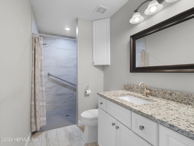 bathroom featuring a shower with curtain, toilet, a textured ceiling, and vanity