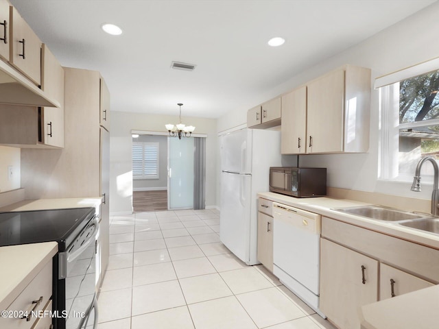 kitchen with sink, white appliances, hanging light fixtures, and light brown cabinetry