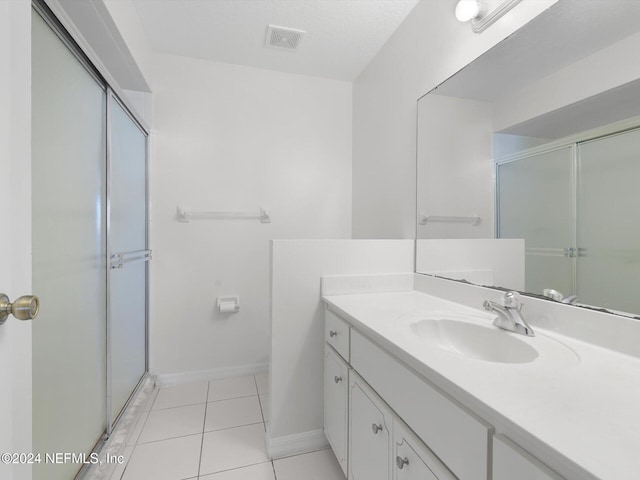 bathroom featuring vanity, tile patterned floors, and an enclosed shower