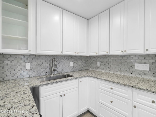 kitchen with white cabinets, tasteful backsplash, and sink