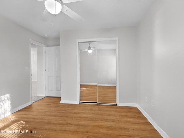 unfurnished bedroom featuring ceiling fan, a closet, and light hardwood / wood-style floors