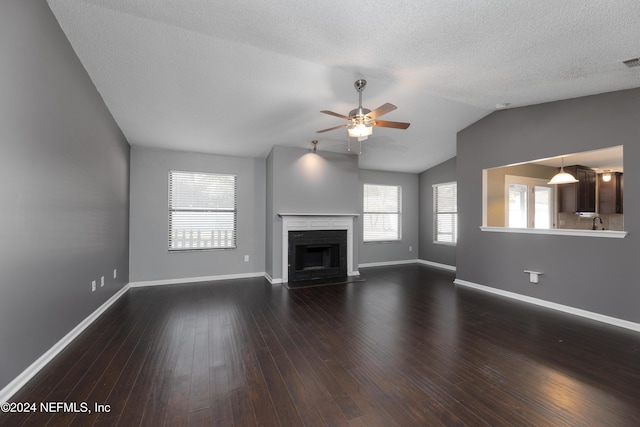 unfurnished living room featuring a textured ceiling, ceiling fan, lofted ceiling, and dark wood-type flooring