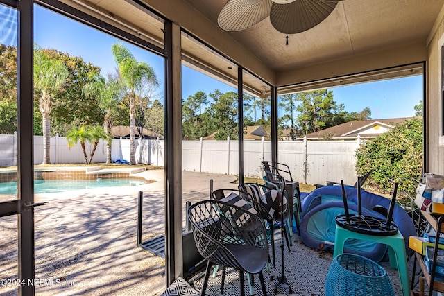 view of patio featuring ceiling fan and a swimming pool with hot tub