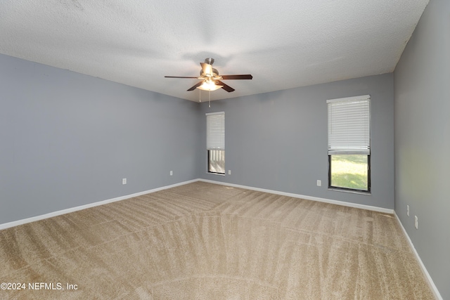 spare room with ceiling fan, carpet floors, and a textured ceiling