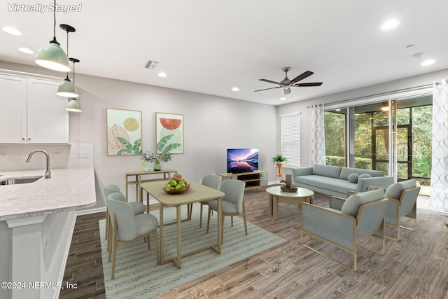 living room featuring hardwood / wood-style floors, ceiling fan, and sink