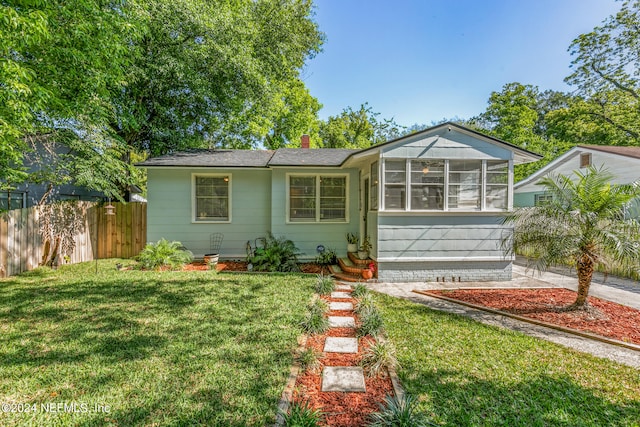 view of front of property with a front lawn and a sunroom