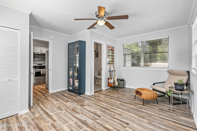 living area with ceiling fan, light hardwood / wood-style floors, and crown molding