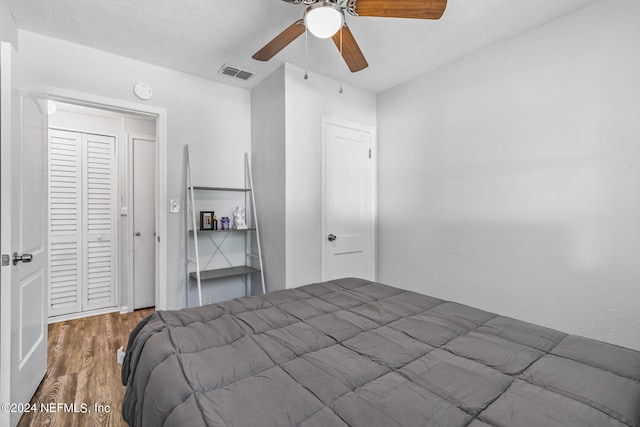 bedroom with ceiling fan, a closet, and wood-type flooring