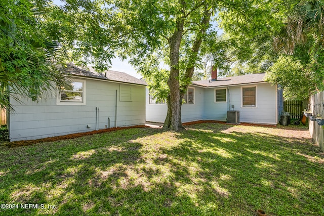 rear view of house featuring a yard and central AC