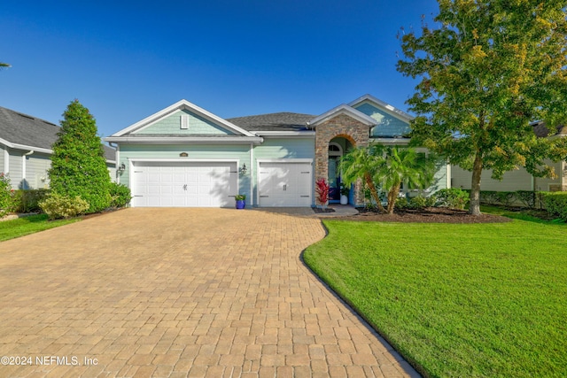 ranch-style house with a garage and a front lawn