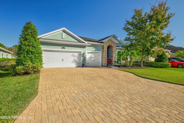 ranch-style home with a garage and a front lawn