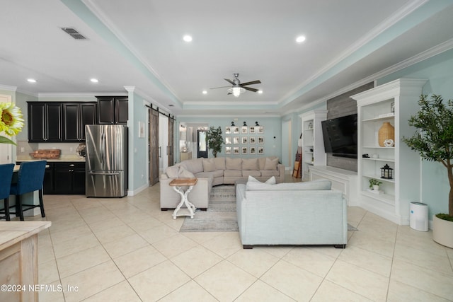 living room featuring ornamental molding, a raised ceiling, ceiling fan, light tile patterned floors, and a barn door