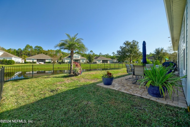 view of yard featuring a water view and a patio