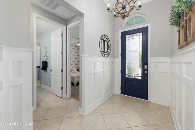 entryway featuring light tile patterned floors and an inviting chandelier