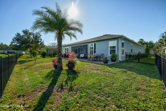 back of property featuring a lawn and a patio area