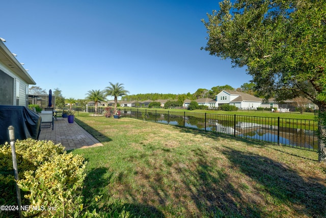 view of yard with a water view and a patio