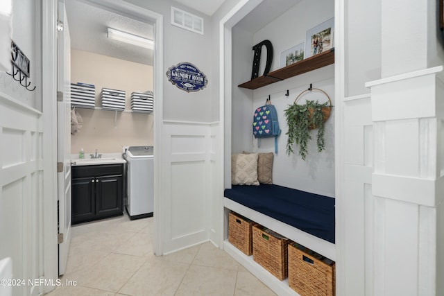 mudroom with washer / dryer, a textured ceiling, light tile patterned floors, and sink