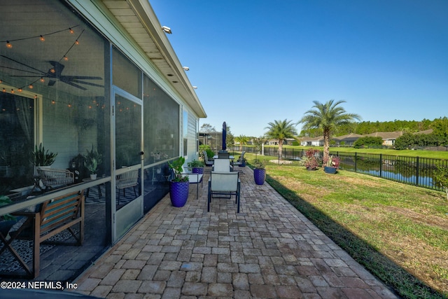 view of patio featuring ceiling fan and a water view