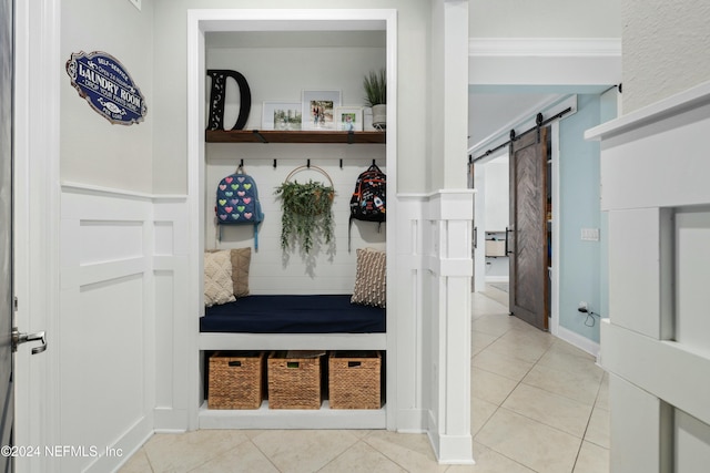 mudroom featuring a barn door and light tile patterned flooring