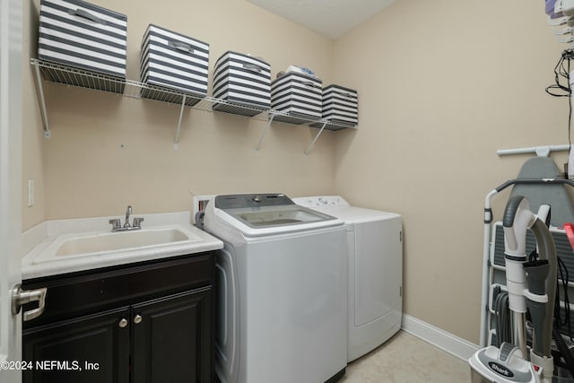 washroom featuring cabinets, independent washer and dryer, and sink