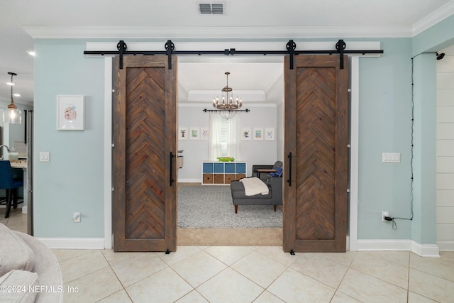 interior space with a barn door, tile patterned floors, and crown molding