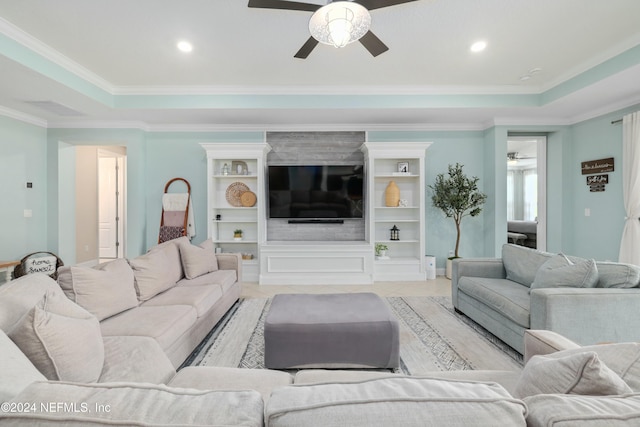 living room with ceiling fan, crown molding, and a tray ceiling