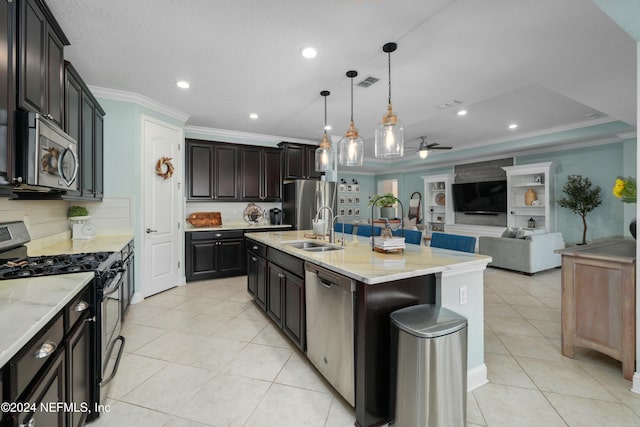 kitchen with pendant lighting, a center island with sink, sink, ceiling fan, and appliances with stainless steel finishes