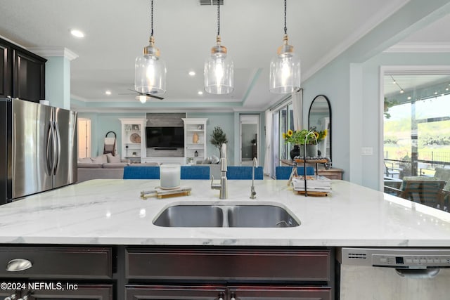 kitchen featuring a kitchen island with sink, sink, crown molding, and appliances with stainless steel finishes